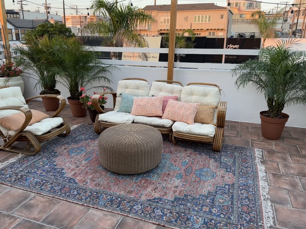 Boho patio lounge with rattan seating and vintage rug set for a boutique brunch