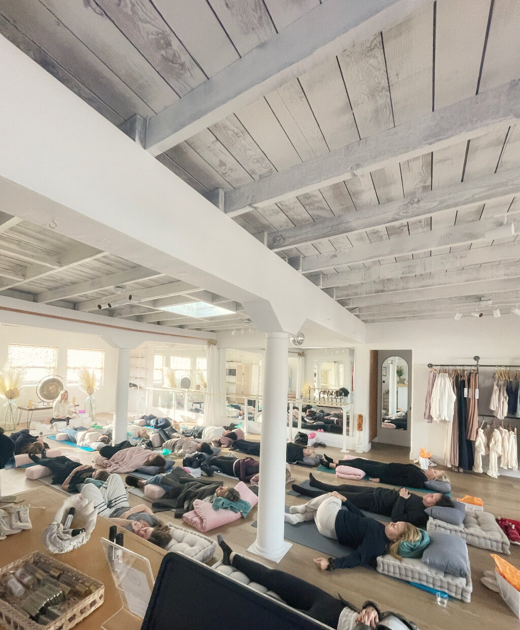 A full sound bath session with guests resting on bolsters and blankets